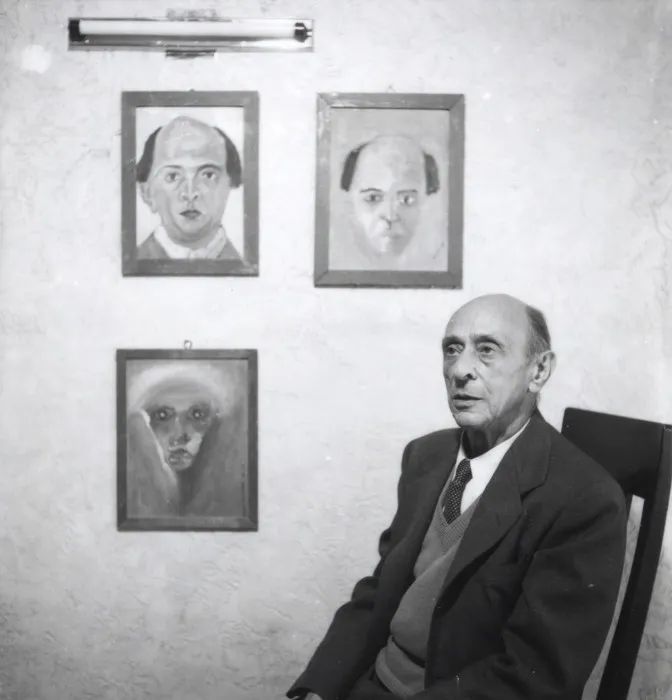 Schoenberg in 1937 with three of his self-portraits